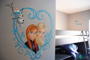 Muurschildering Frozen met Anna, Elsa en Olaf in een hart van ijs met namen kinderen op de achtergrond