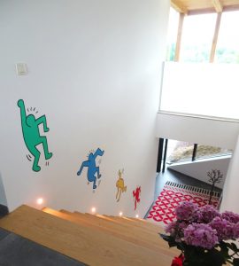 Decoratieve muurschildering bij trap in Keith Haring stijl