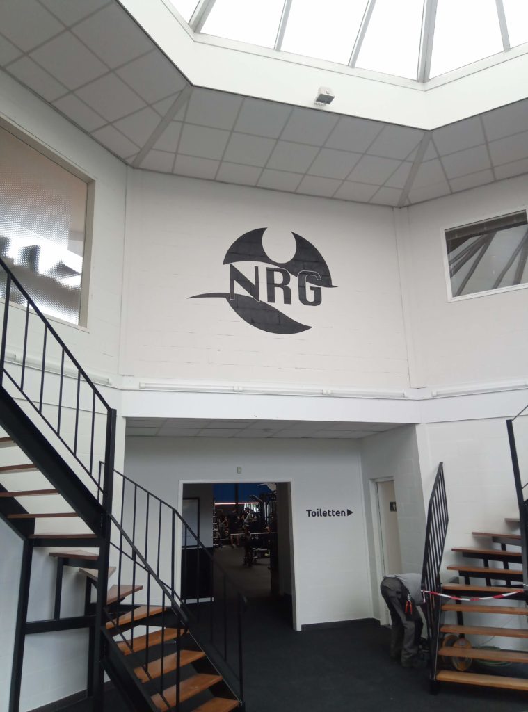 geschilderd logo in de inkomhal van fintessclub NRG