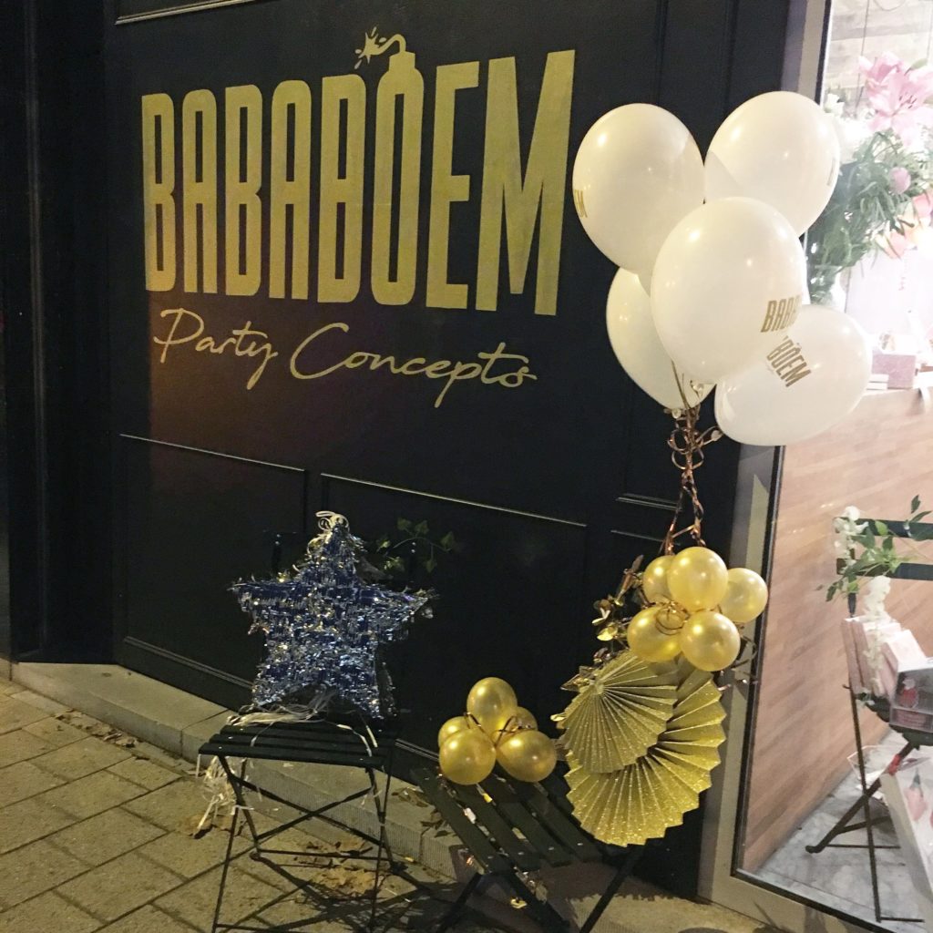 geschilderd logo met gouden letters op een gevel voor Bababoem