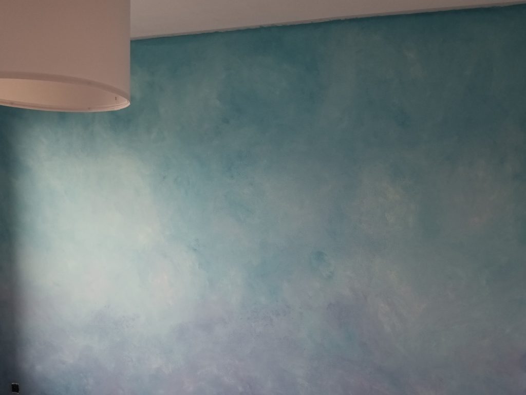 geschilderde muur met decoratieve verftechniek met lavendel en turquoise tinten