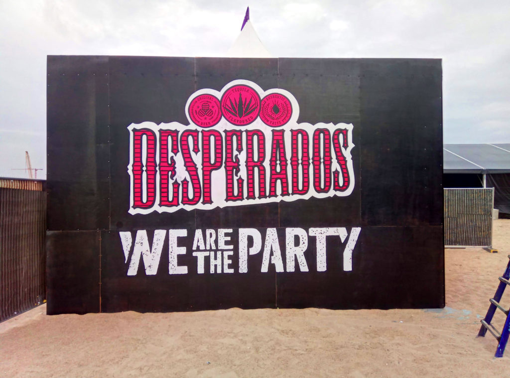 muurschildering met branding van Desperados bier op een zomerfestival aan zee