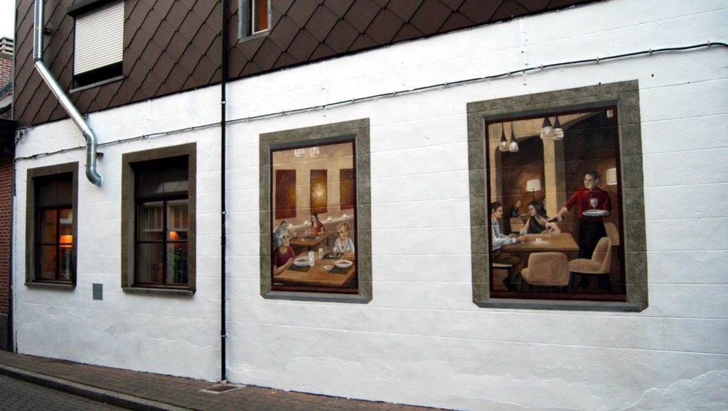 muurschildering op de gevel met twee ramen waarin mensen eten in een restaurant