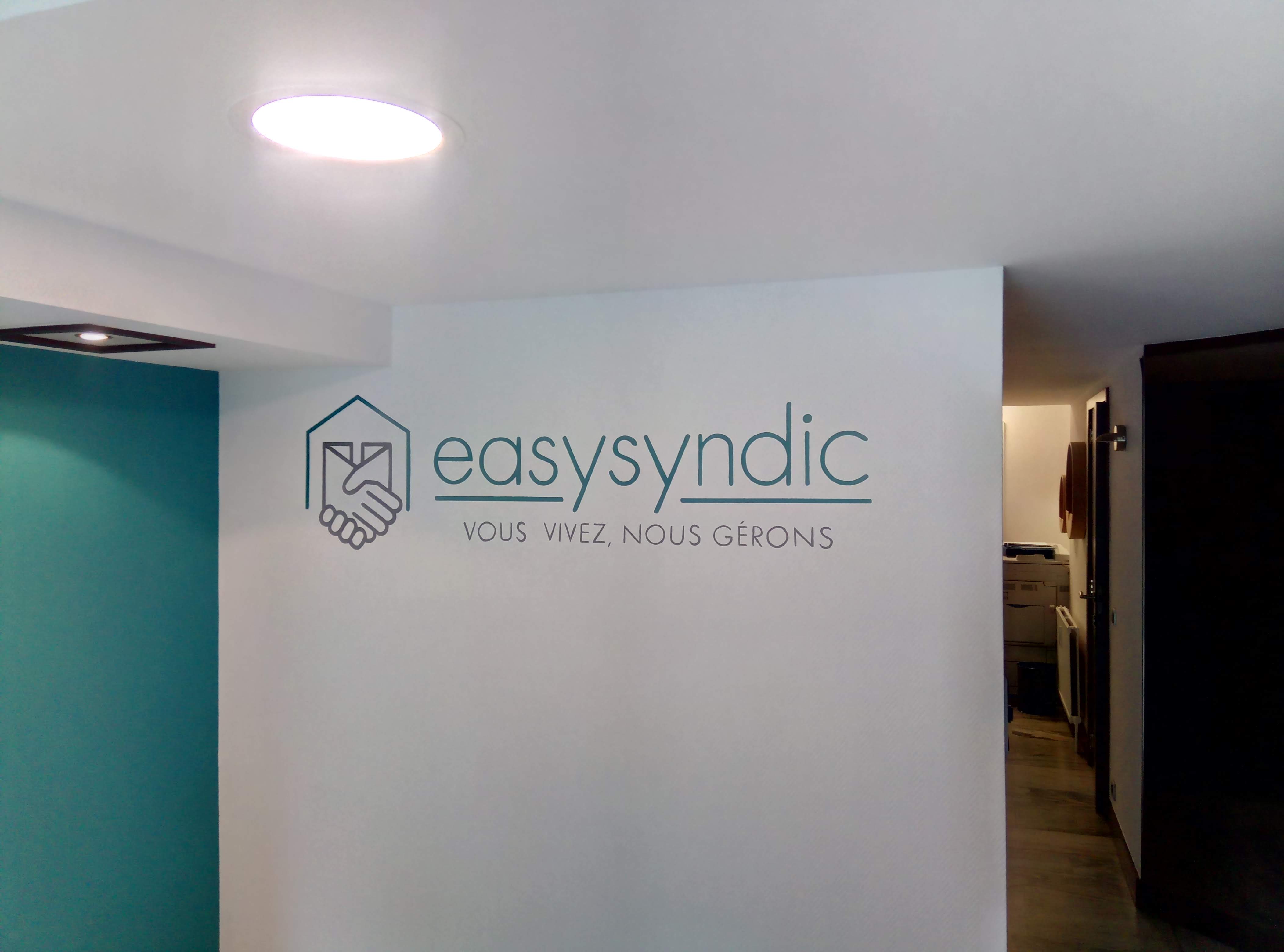 muurschildering van het logo van Easysyndic in de inkomhal